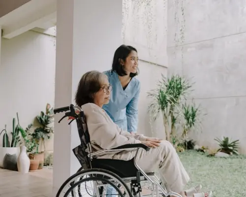 Verpleegster verzorgt oudere vrouw in rolstoel