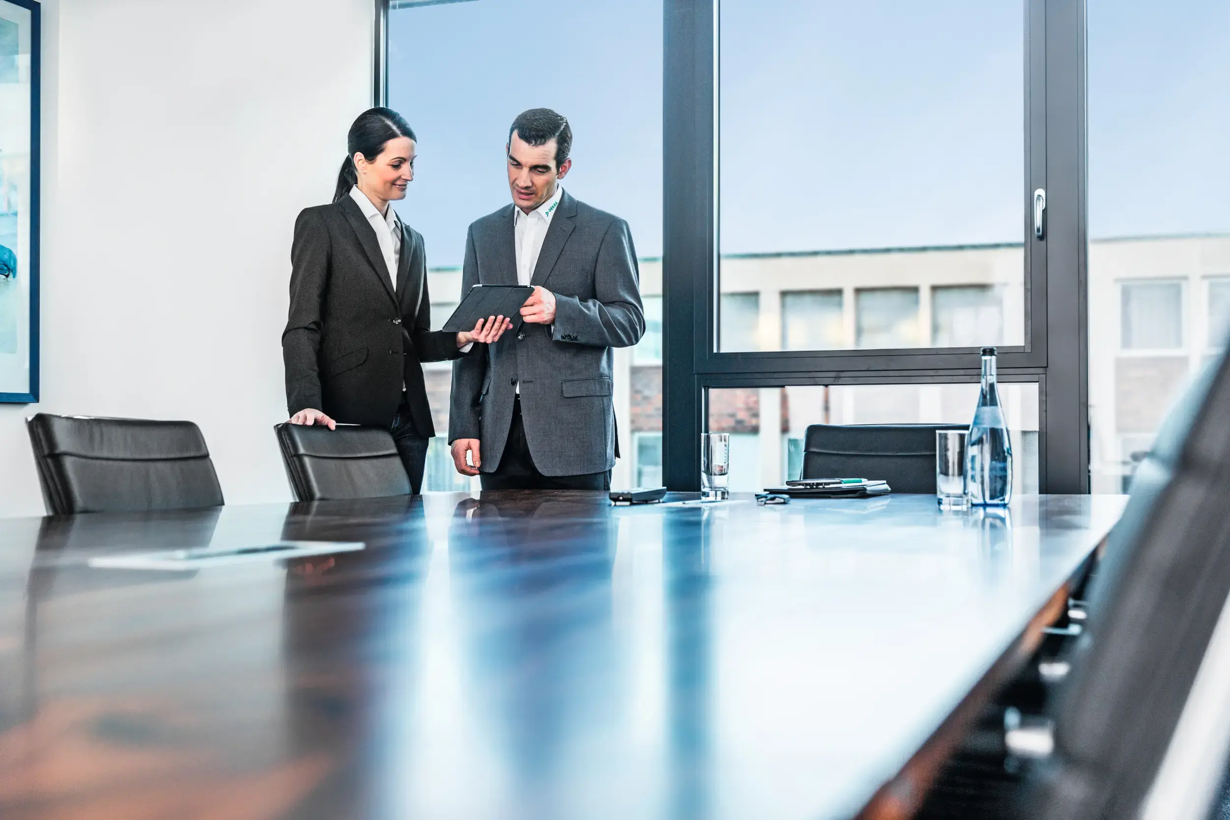 Vrouw toont document aan collega in vergaderruimte Vrouw toont document aan collega in vergaderruimte