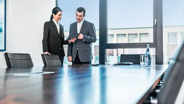Vrouw toont document aan collega in vergaderruimte Vrouw toont document aan collega in vergaderruimte