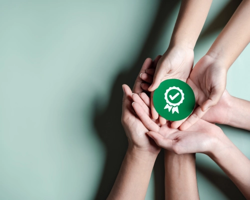 Handen samen houden een afbeelding van een vinkje vast