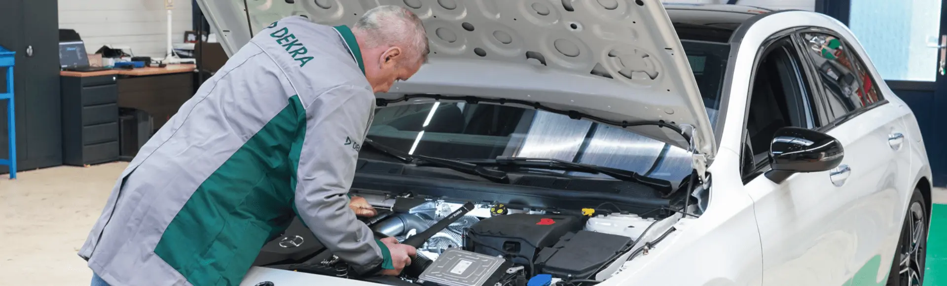 DEKRA employee inspects the hood of a car