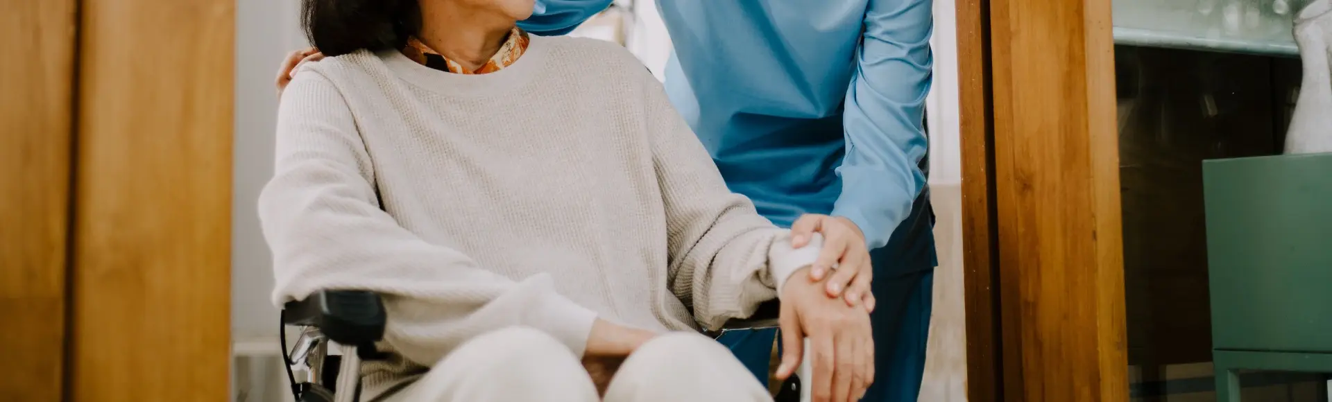 Verpleegster helpt oudere vrouw in rolstoel Verpleegster helpt oudere vrouw in rolstoel