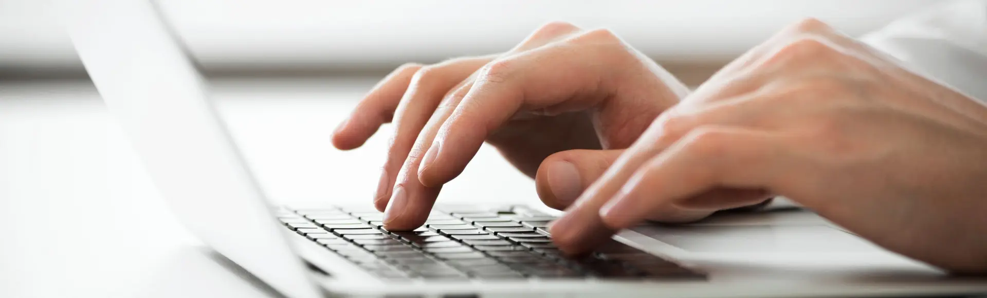 ISO 27001 Handen die typen op een laptop