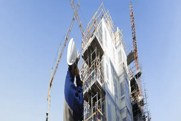 Inżynier na placu budowy oceniający stan obiektu. Audyt techniczny budynku w zakresie konstrukcji, instalacji i bezpieczeństwa.