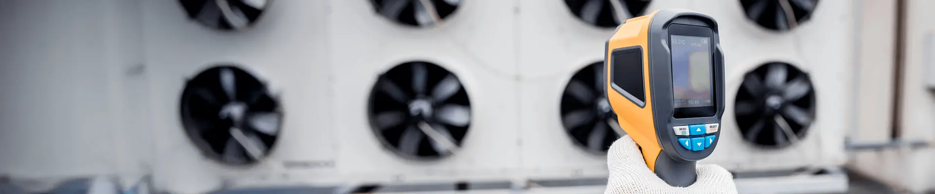 Kamera termowizyjna w dłoni, wykorzystywana do analizy strat ciepła w budynku. Badania termowizyjne obiektów.