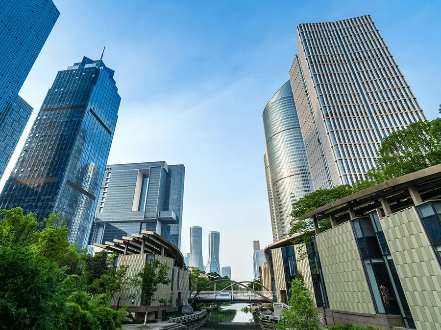 Nowoczesny kompleks biurowy z wieżowcami, zielenią i kanałem wodnym, nawiązujący do standardów zrównoważonego budownictwa BREEAM.