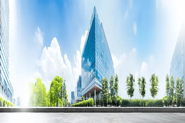 Nowoczesny, przeszklony budynek biurowy otoczony zielenią. Eksploatacja obiektu.