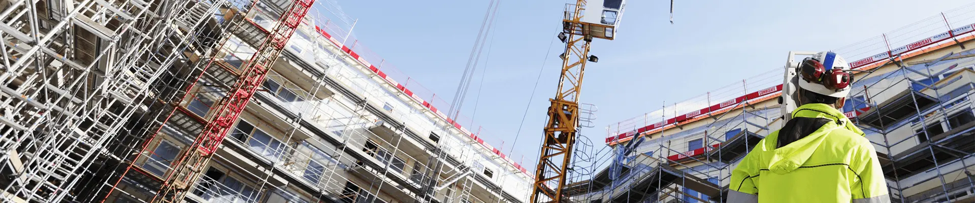 Plac budowy z rusztowaniami i dźwigiem. Inżynier BREEAM wspierający proces certyfikacji.