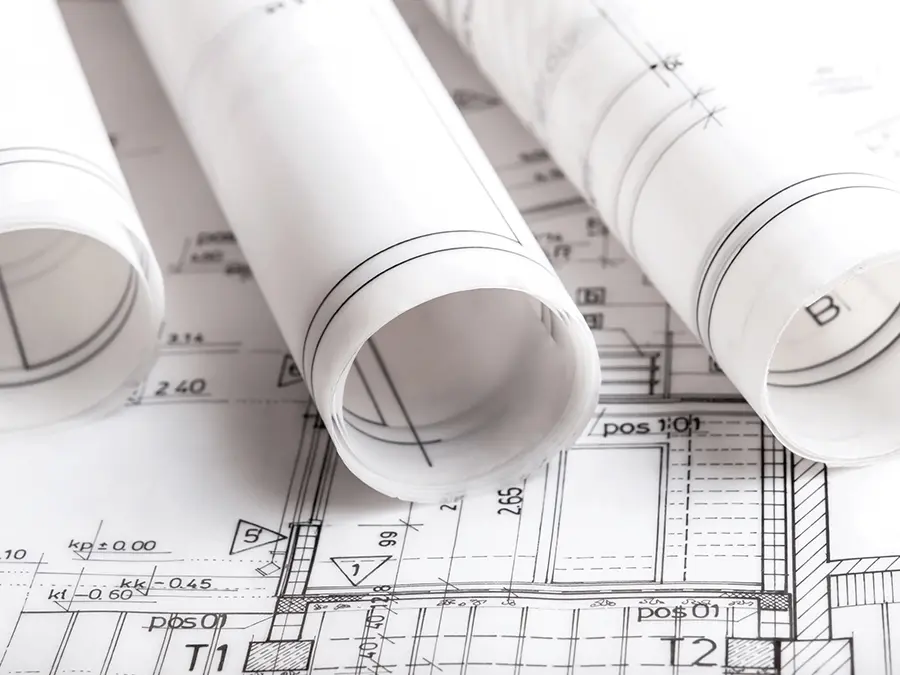Zrolowane rysunki techniczne na planach budynku. Koordynacja projektu budowlanego.