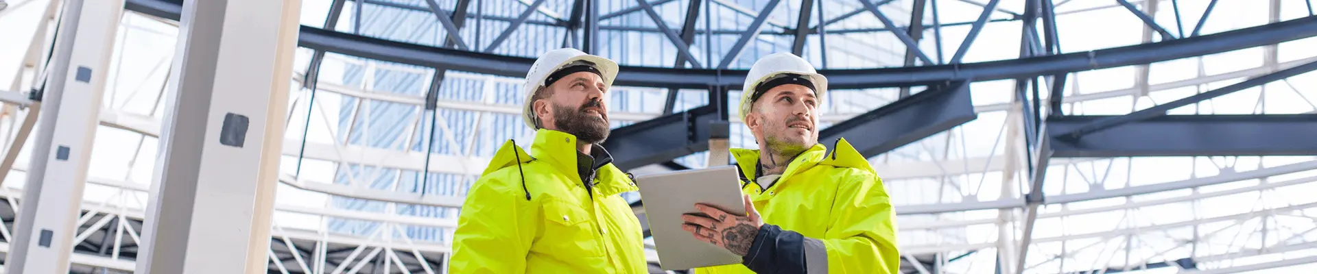 Dwóch inżynierów na placu budowy, realizujących  nadzór inwestorski nad realizacją robót budowlanych.