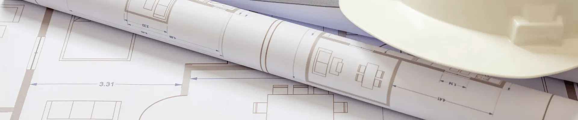 Rysunki techniczne oraz kask ochronny na dokumentacji projektowej. Organizacja projektu budowlanego na etapie przygotowania inwestycji.