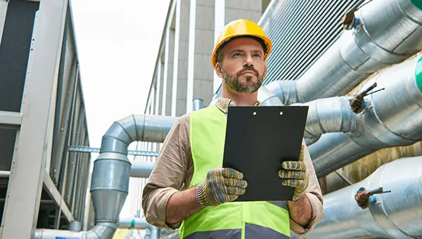 Inspektor przeprowadzający kontrolę instalacji gazowej w obiekcie. Przegląd instalacji gazowych w ramach eksploatacji obiektu.