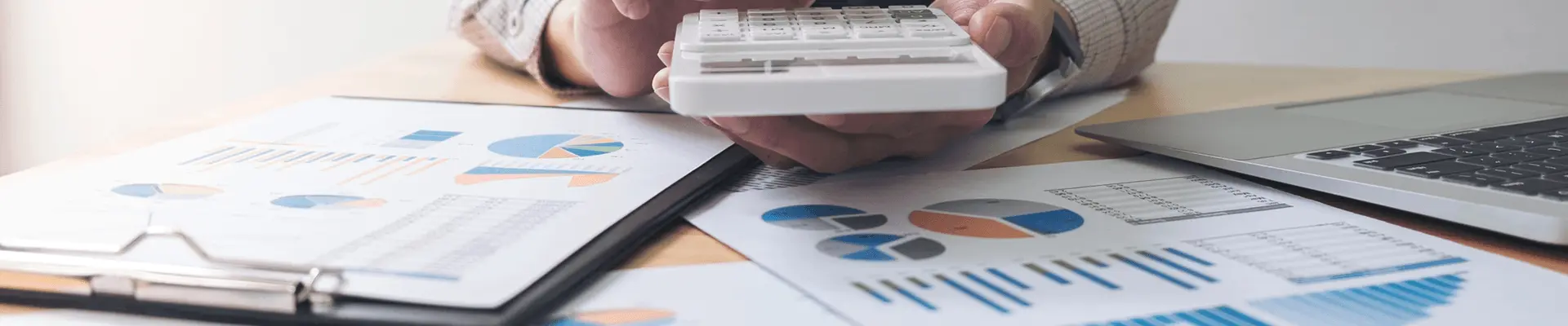 Kalkulator i zestawienia finansowe na biurku. Zarządzanie kosztami inwestycji budowlanej.