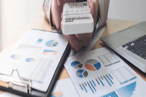 Kalkulator i zestawienia finansowe na biurku. Zarządzanie kosztami inwestycji budowlanej.