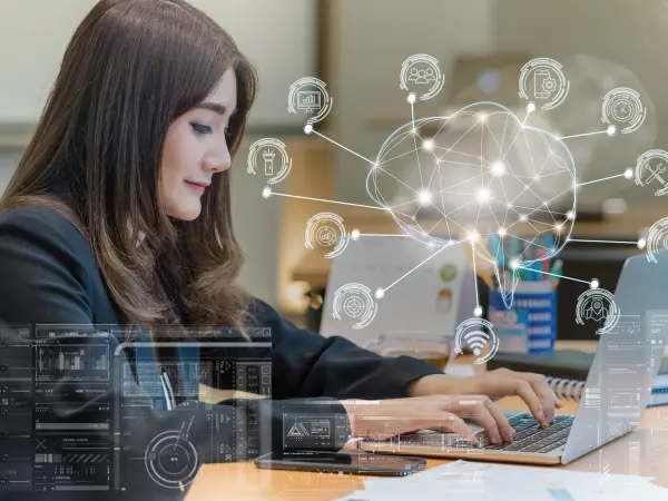 A businesswoman working on a laptop with an AI-inspired digital overlay symbolizing data analytics, automation, and cloud computing. A businesswoman working on a laptop with an AI-inspired digital overlay symbolizing data analytics, automation, and cloud computing.