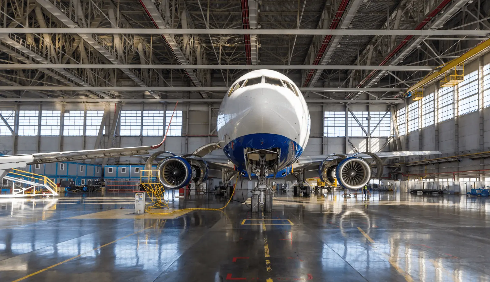 View from below a passenger aircraft in a hangar.