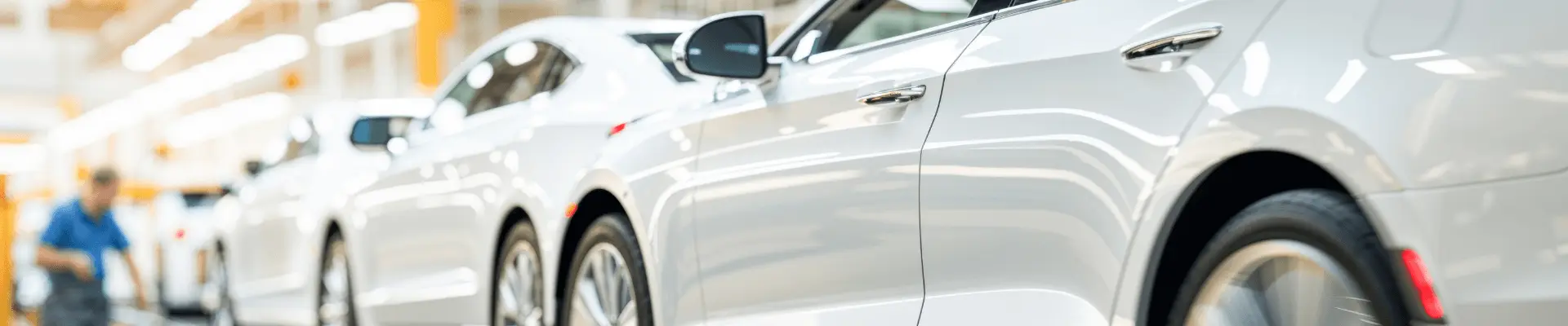 Several silver-colored cars in an assembly line. Several silver-colored cars in an assembly line.