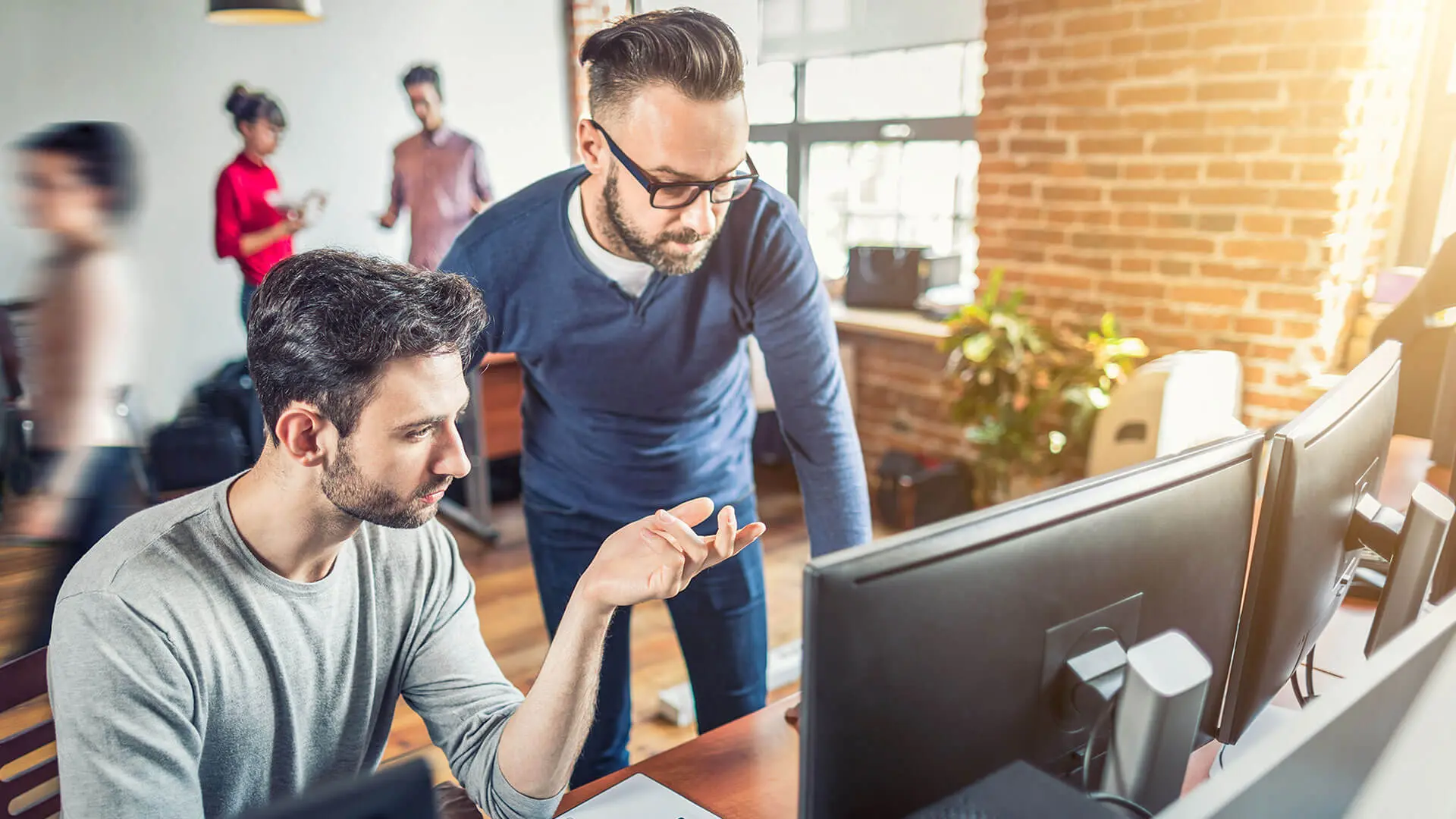 Two men looking at a desktop