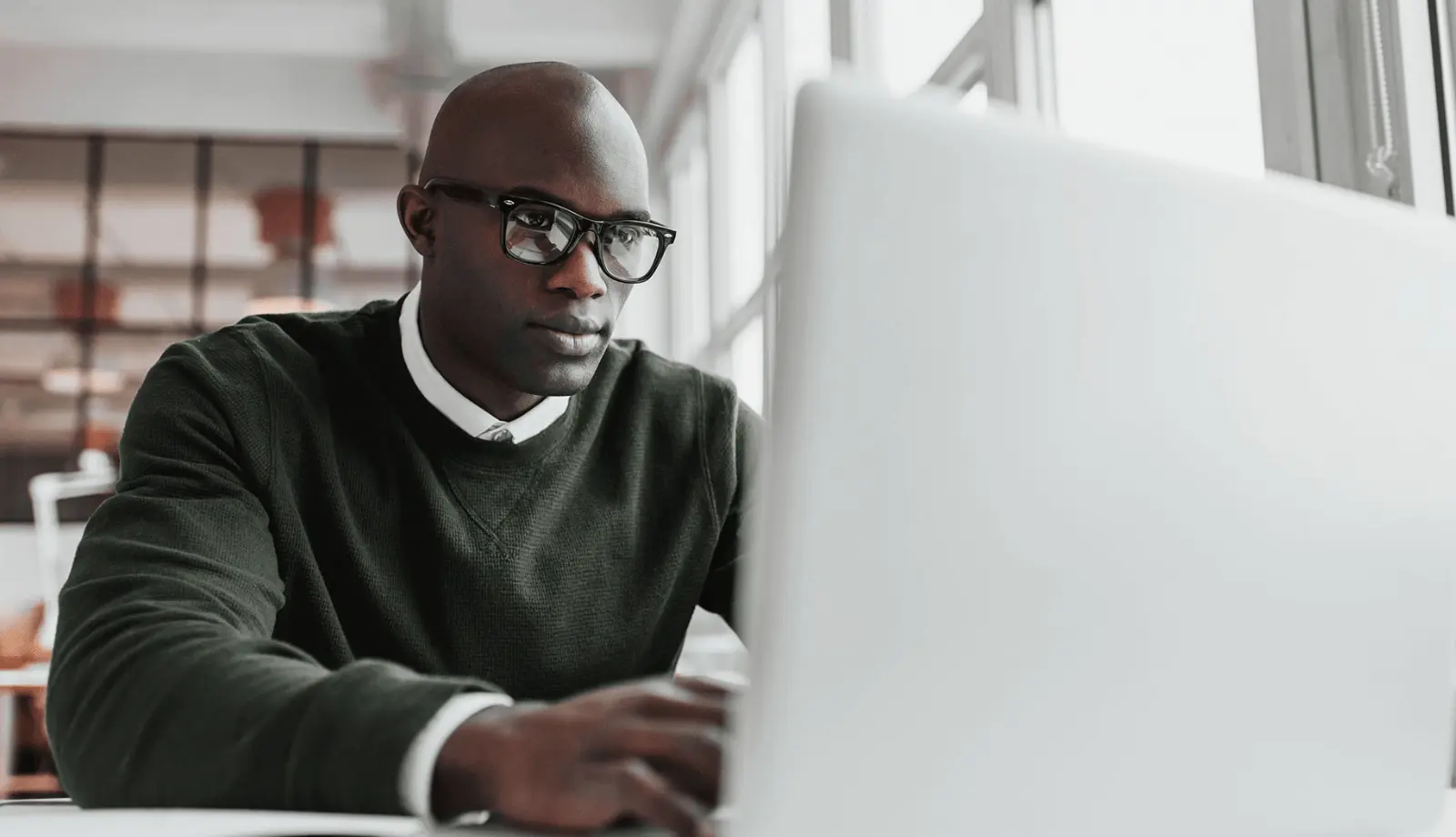 A person sitting infront of a comupter. Different data is shown