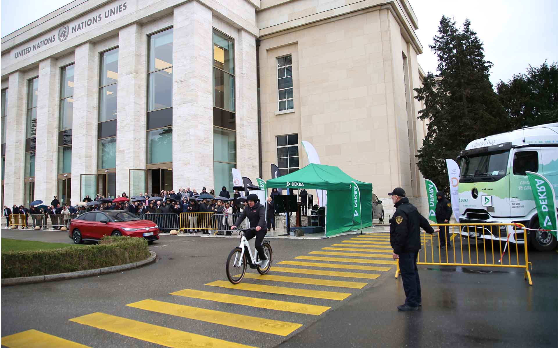 Car, truck and cyclist at a V2X demonstration by DEKRA in Geneva at an intersection where a potentially dangerous situation is defused.