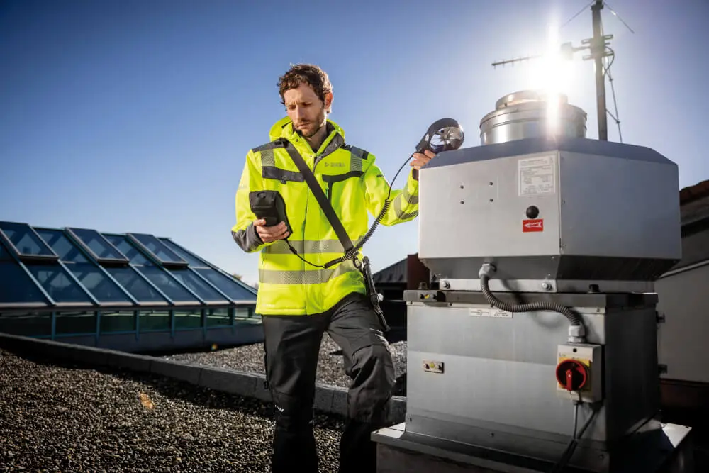 DEKRA expert evaluating the efficiency of a rooftop smoke extraction system for fire safety.
