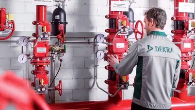 DEKRAn tarkastaja sammutuslaitteiston edessä