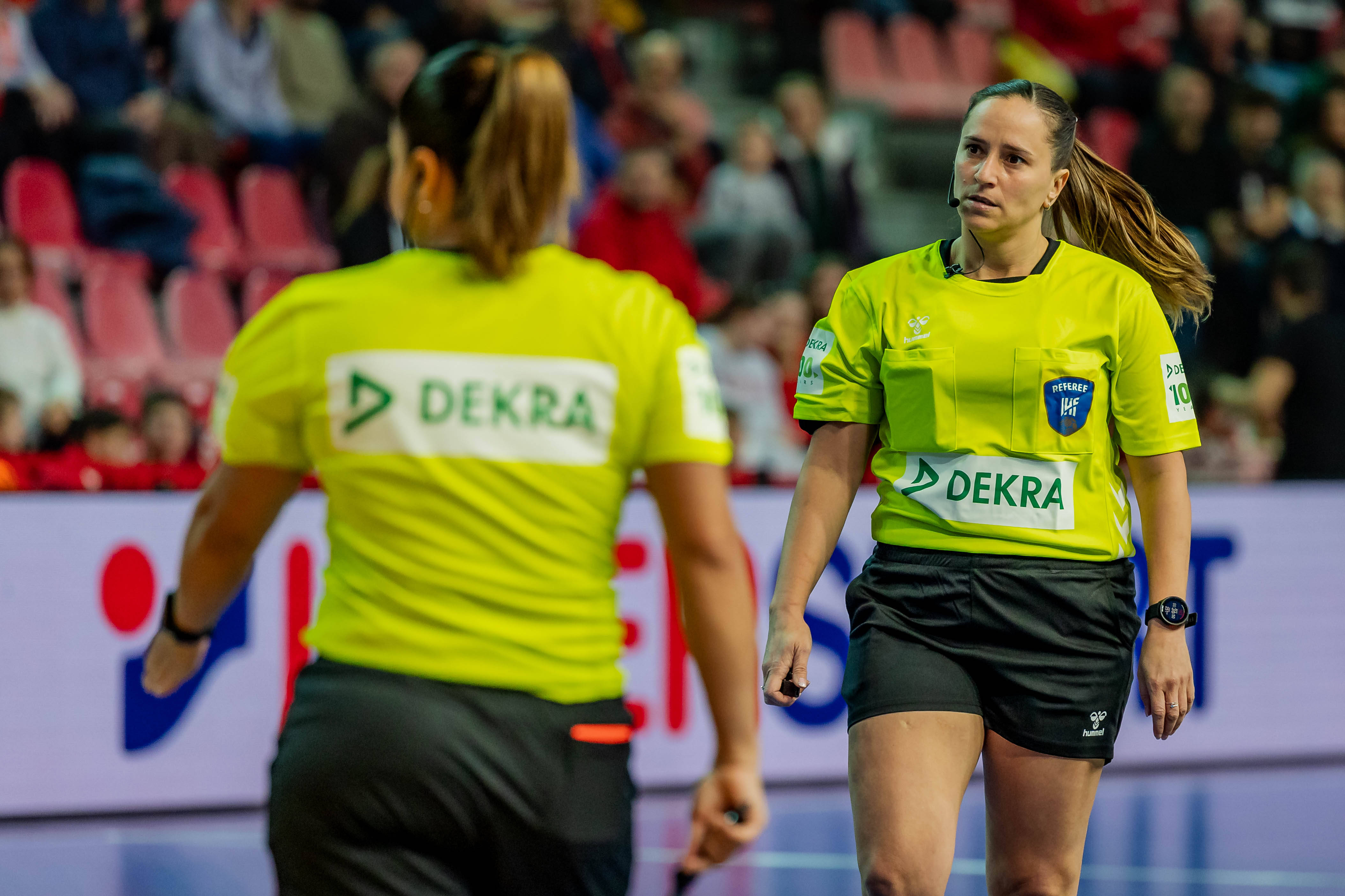 Female referees wearing a jersey with the DEKRA logo on it