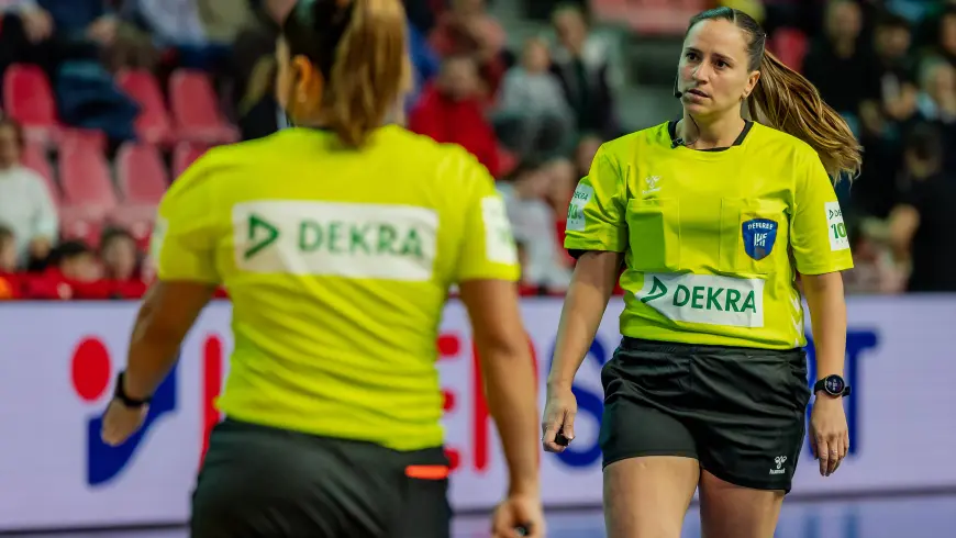 Female referees wearing a jersey with the DEKRA logo on it