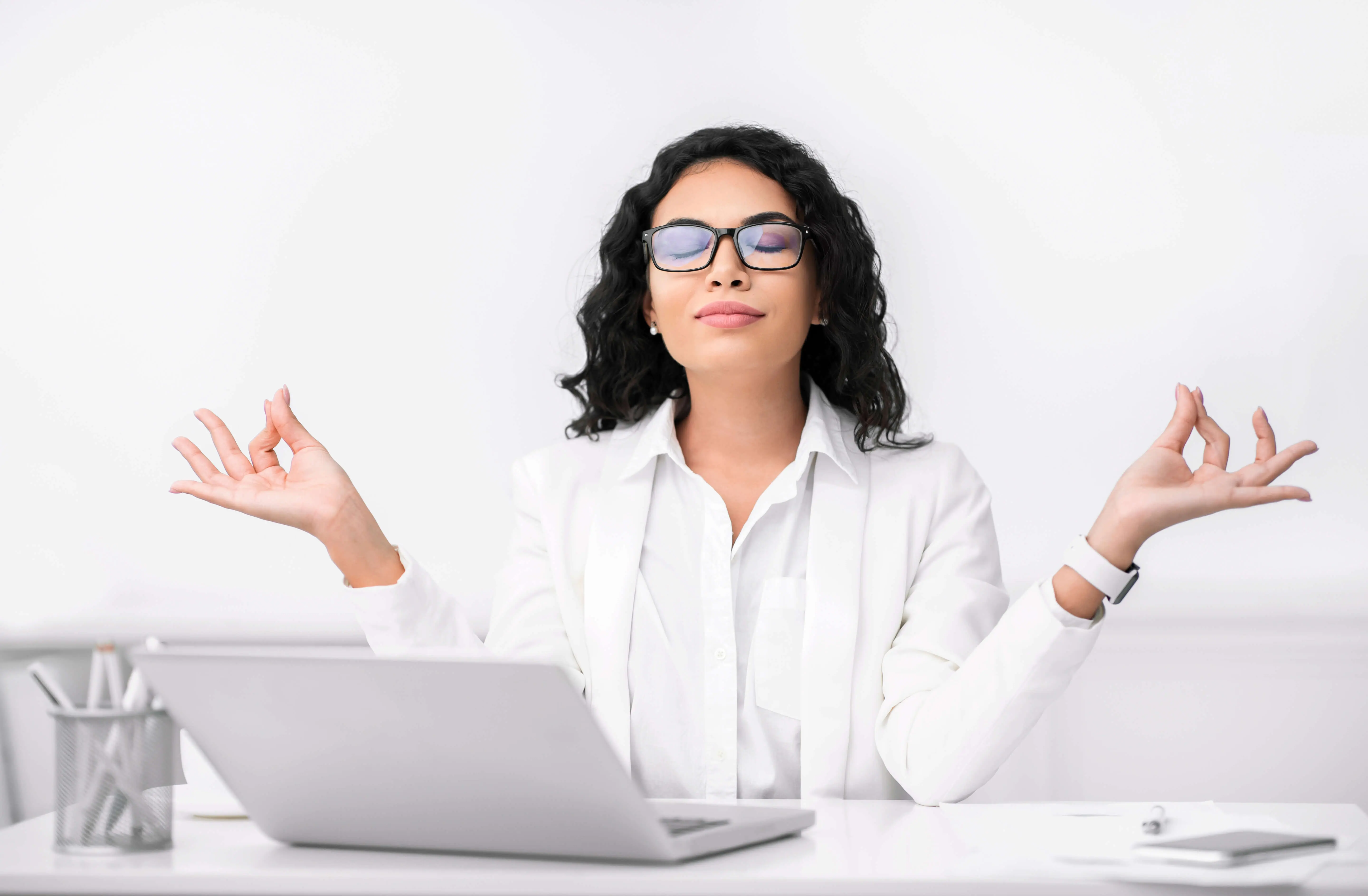 woman meditates behind desk