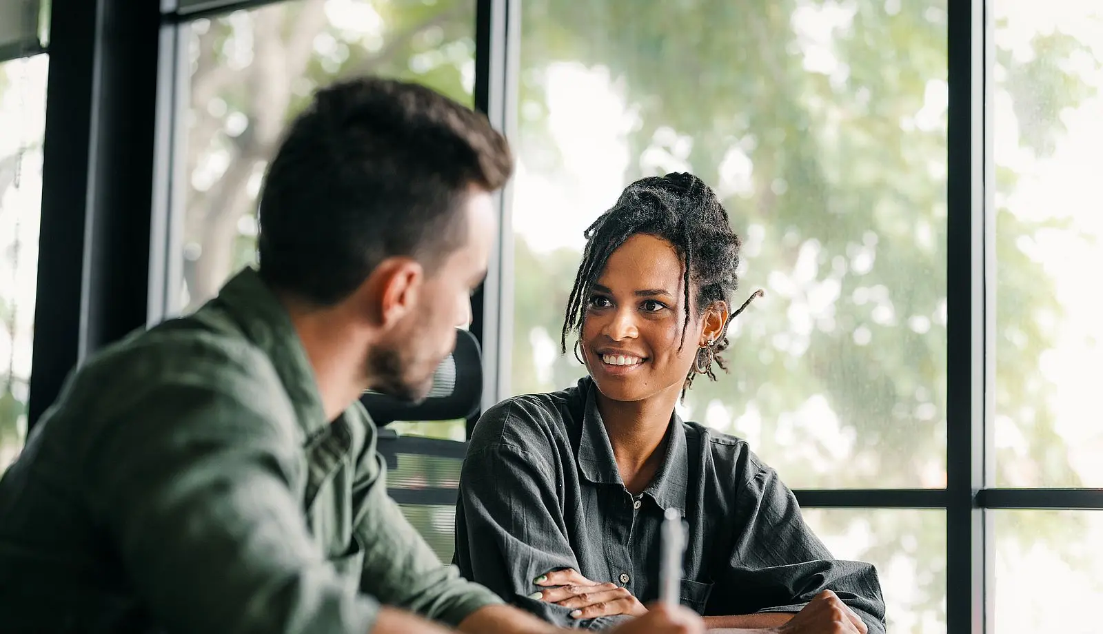 business buidling with glass front and green plants in front of it