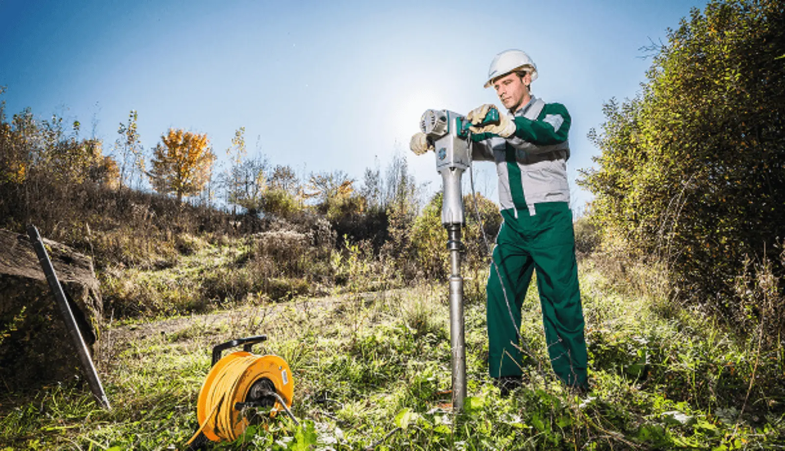 DEKRA field technician operating drilling equipment outdoors