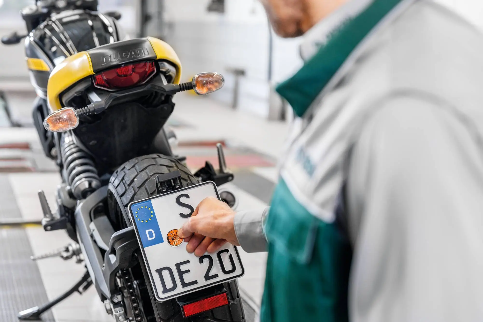 Ingeniero de pruebas de DEKRA coloca una pegatina en una moto.