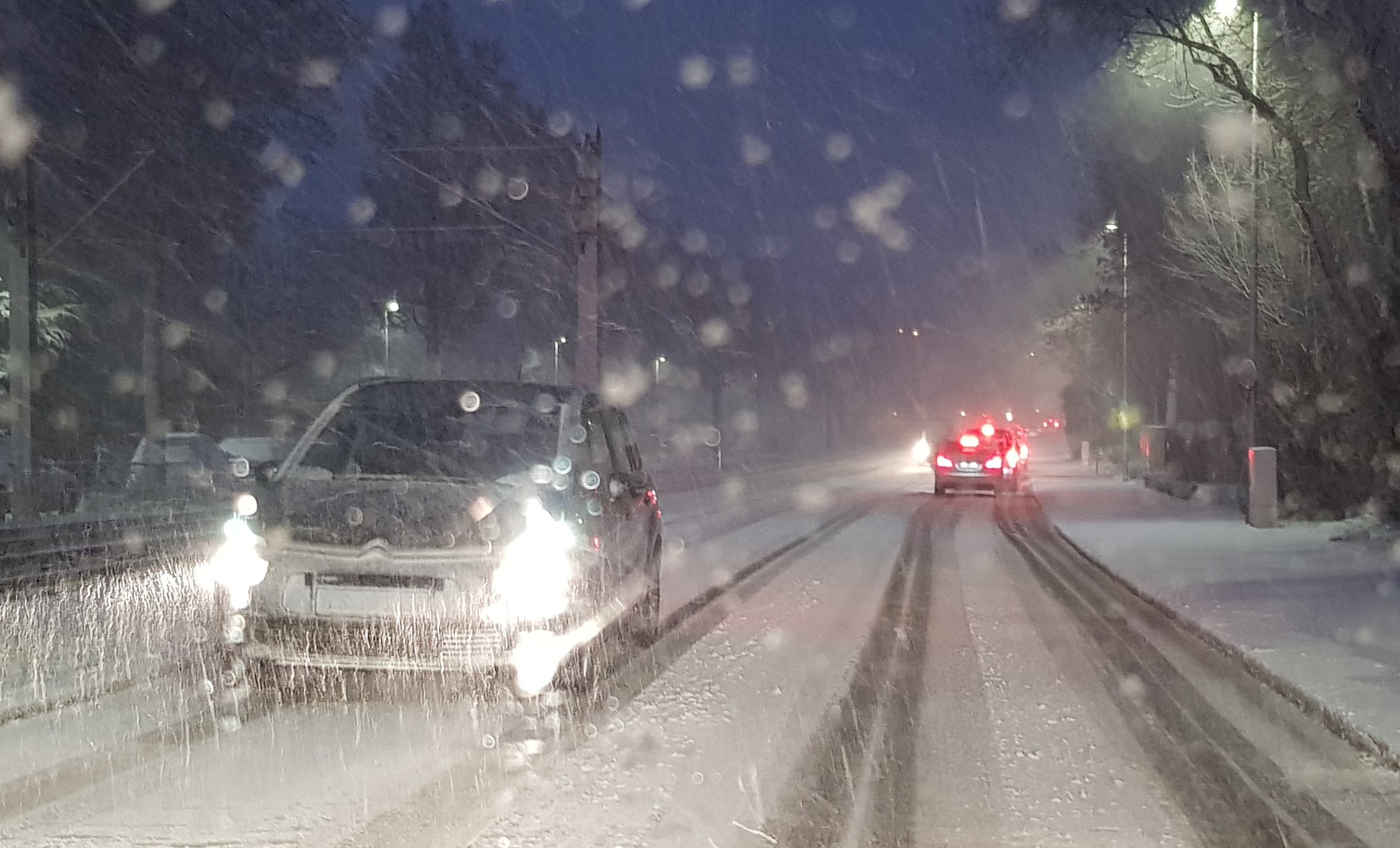 Eine verschneite Winterstraße mit Autos darauf