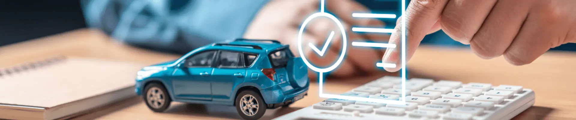 A person is seated behind a desk, interacting with a calculator. On the desk are a calculator, a small model car, and a notepad. Above the calculator is a floating digital document with a checkmark symbolizes approval