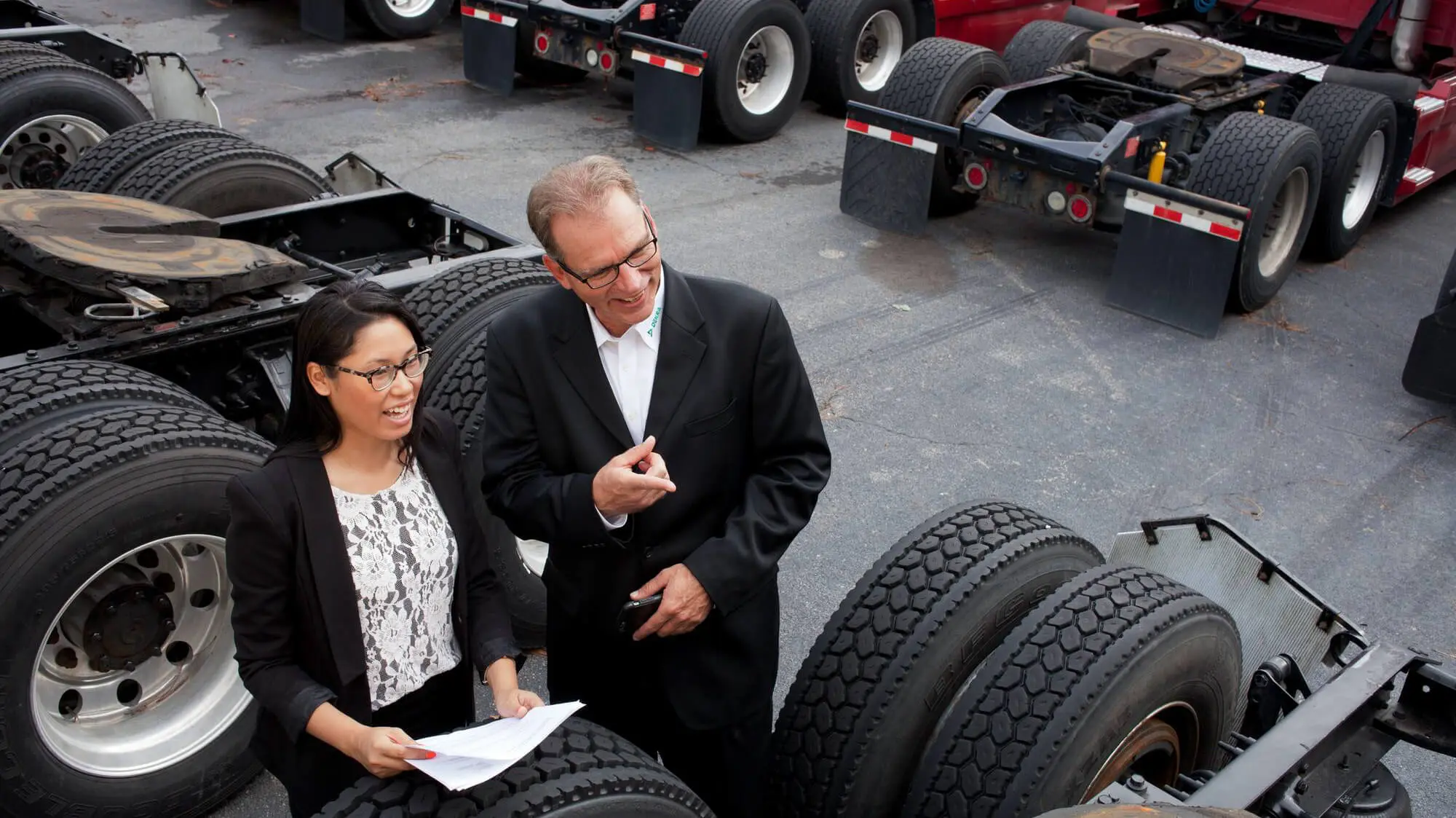 Man bekijkt en geeft uitleg over vrachtwagen trekker aan vrouw Man bekijkt en geeft uitleg over vrachtwagen trekker aan vrouw