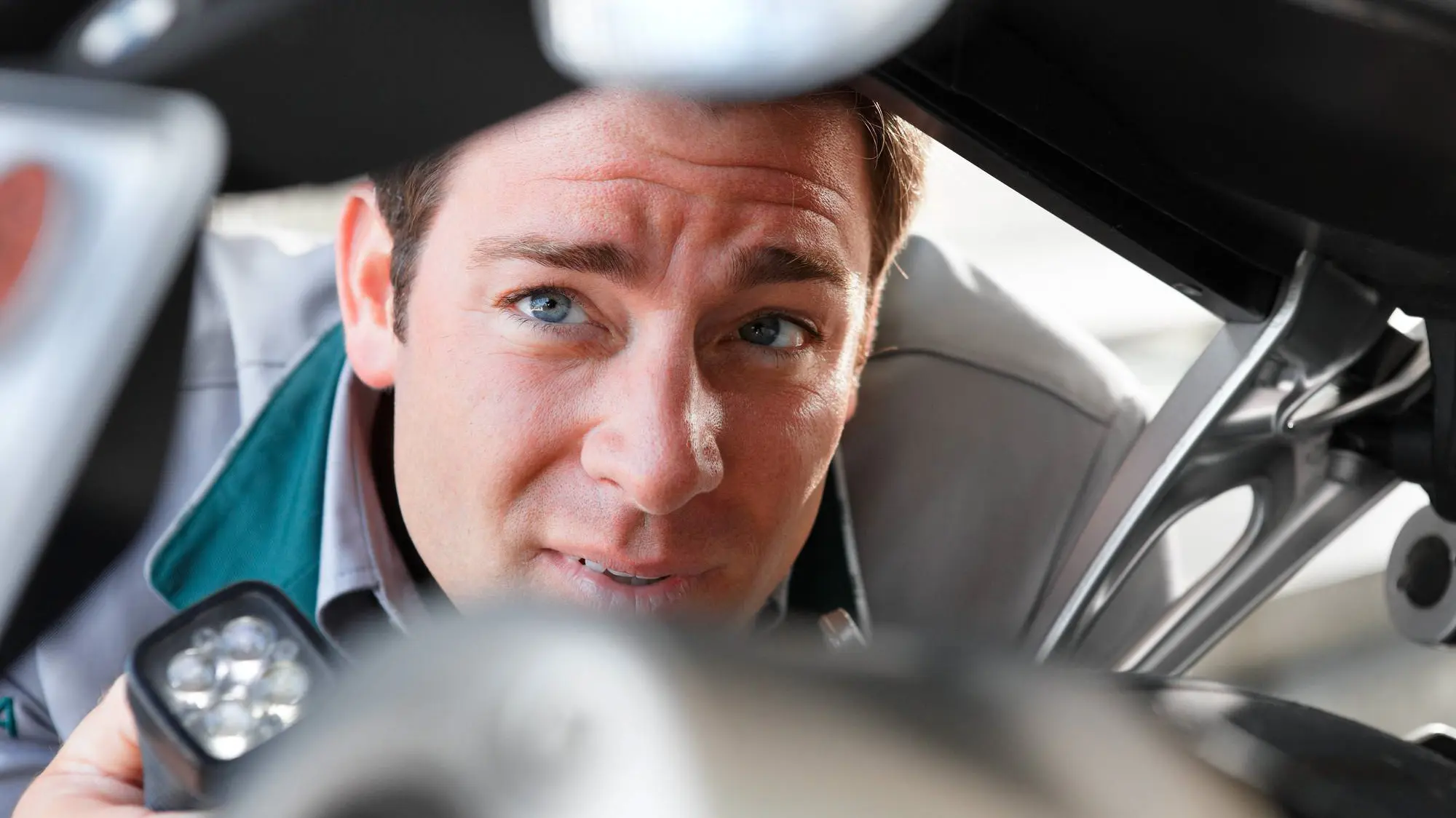 Expert met zaklamp voert diepgaand onderzoek aan personenwagen Expert met zaklamp voert diepgaand onderzoek aan personenwagen