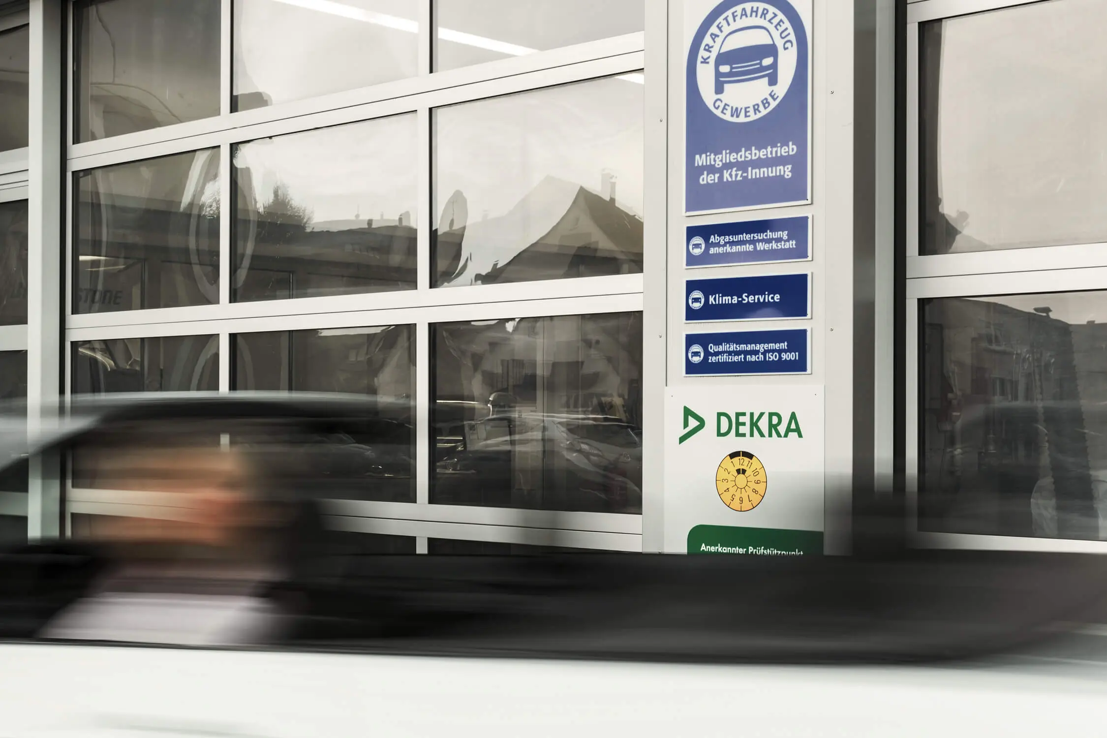 Vorbeifahrendes Cabrio vor DEKRA Prüfstelle