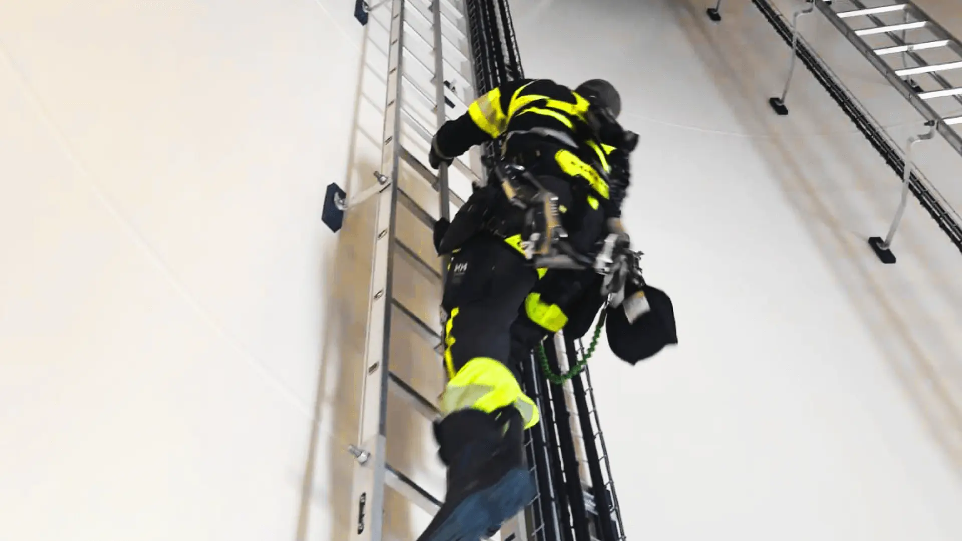 Experte in Schutzkleidung klettert eine Leiter hoch Experte in Schutzkleidung klettert eine Leiter hoch