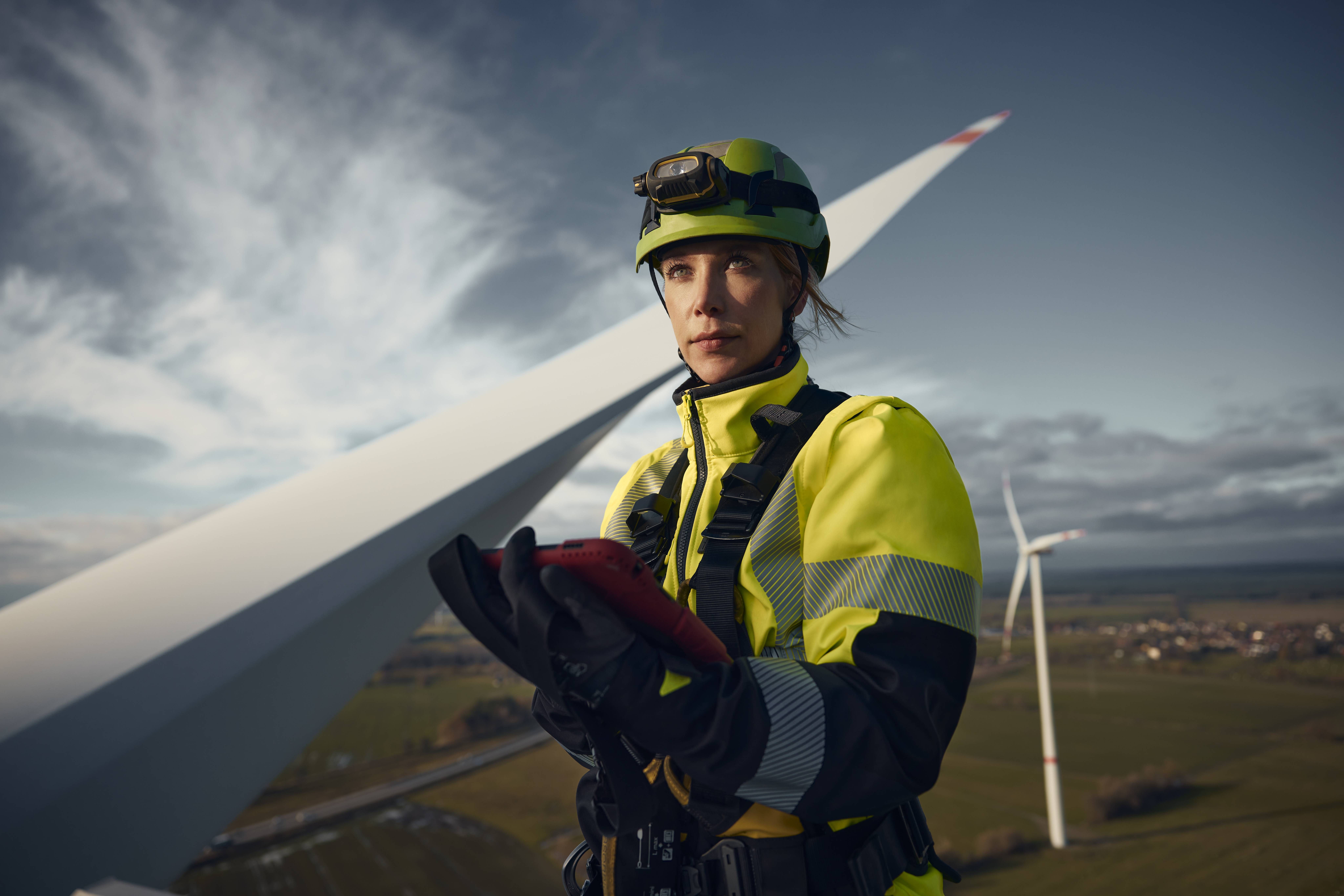 Anna-Louisa Kruse, Sachverständige für Windenergieanlagen bei DEKRA, in Arbeitskleidung und Kletterausrüstung auf einer Windkraftanlage Anna-Louisa Kruse, Sachverständige für Windenergieanlagen bei DEKRA, in Arbeitskleidung und Kletterausrüstung auf einer Windkraftanlage