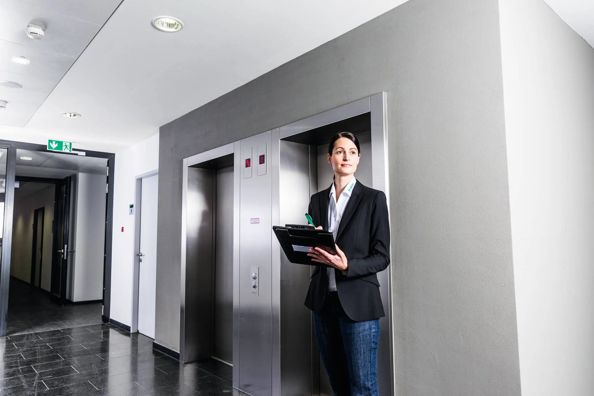 DEKRA Prüferin vor einem Aufzug