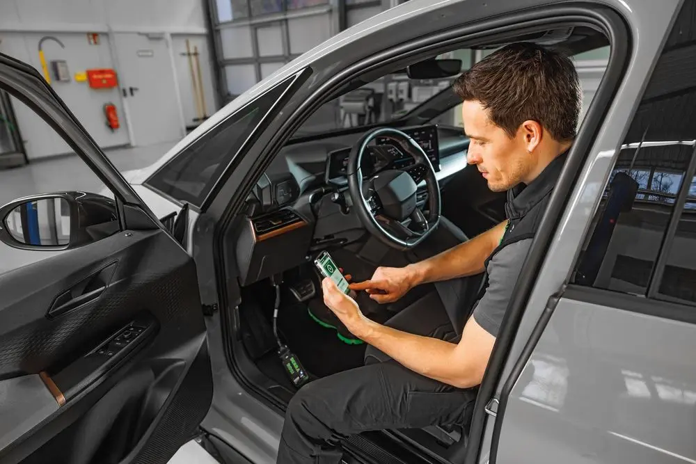 Prüfer führt Batterietest an Elektrofahrzeug durch