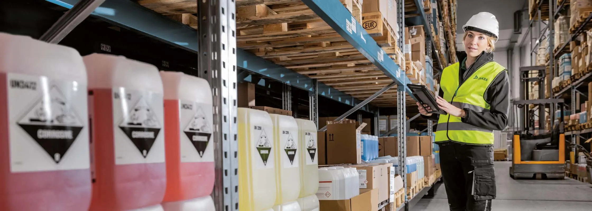Frau mit Arbeitskleidung in einer Industriehalle Frau mit Arbeitskleidung in einer Industriehalle