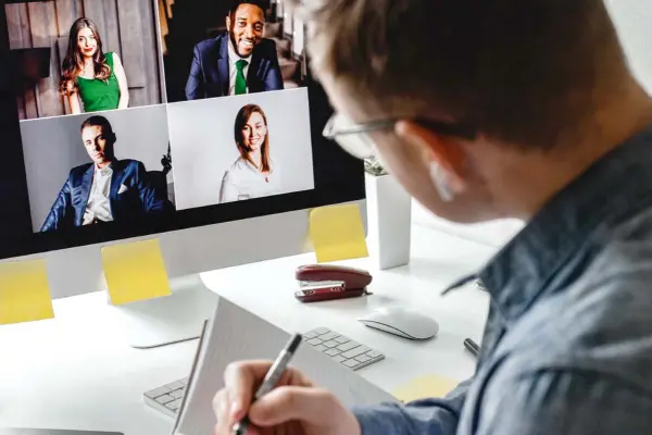 Mann vor dem Bildschirm führt Videokonferenz Mann vor dem Bildschirm führt Videokonferenz