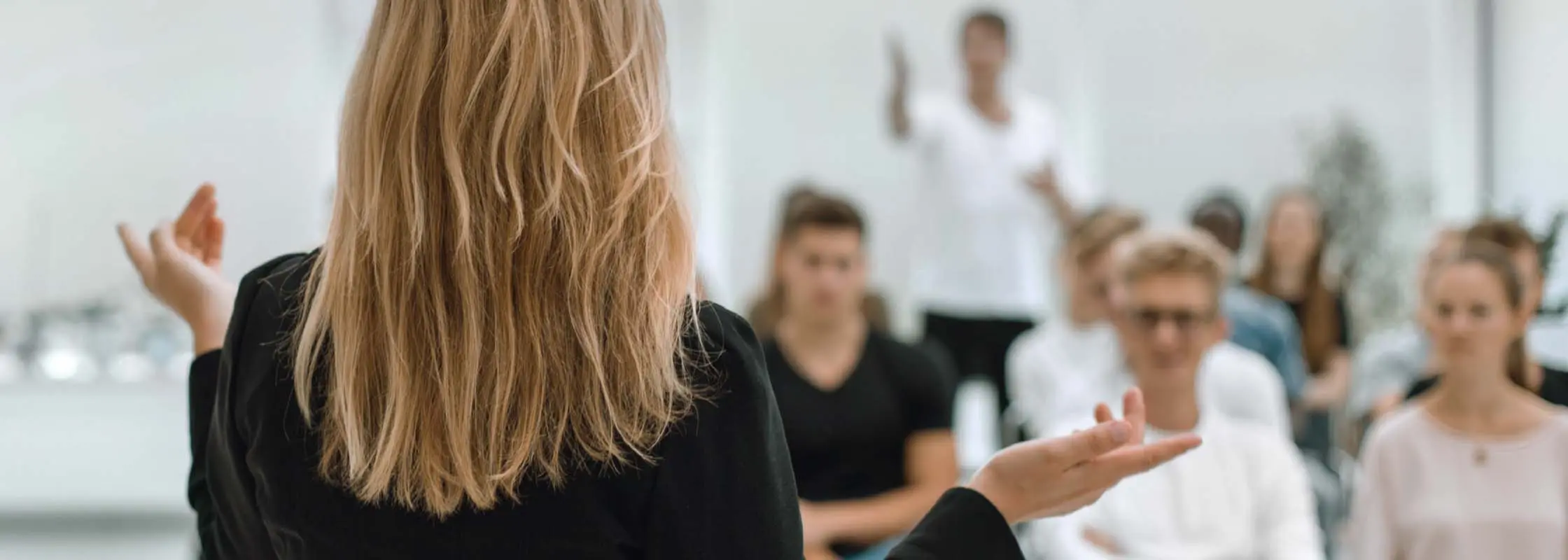 Frau hält einen Vortrag vor Publikum