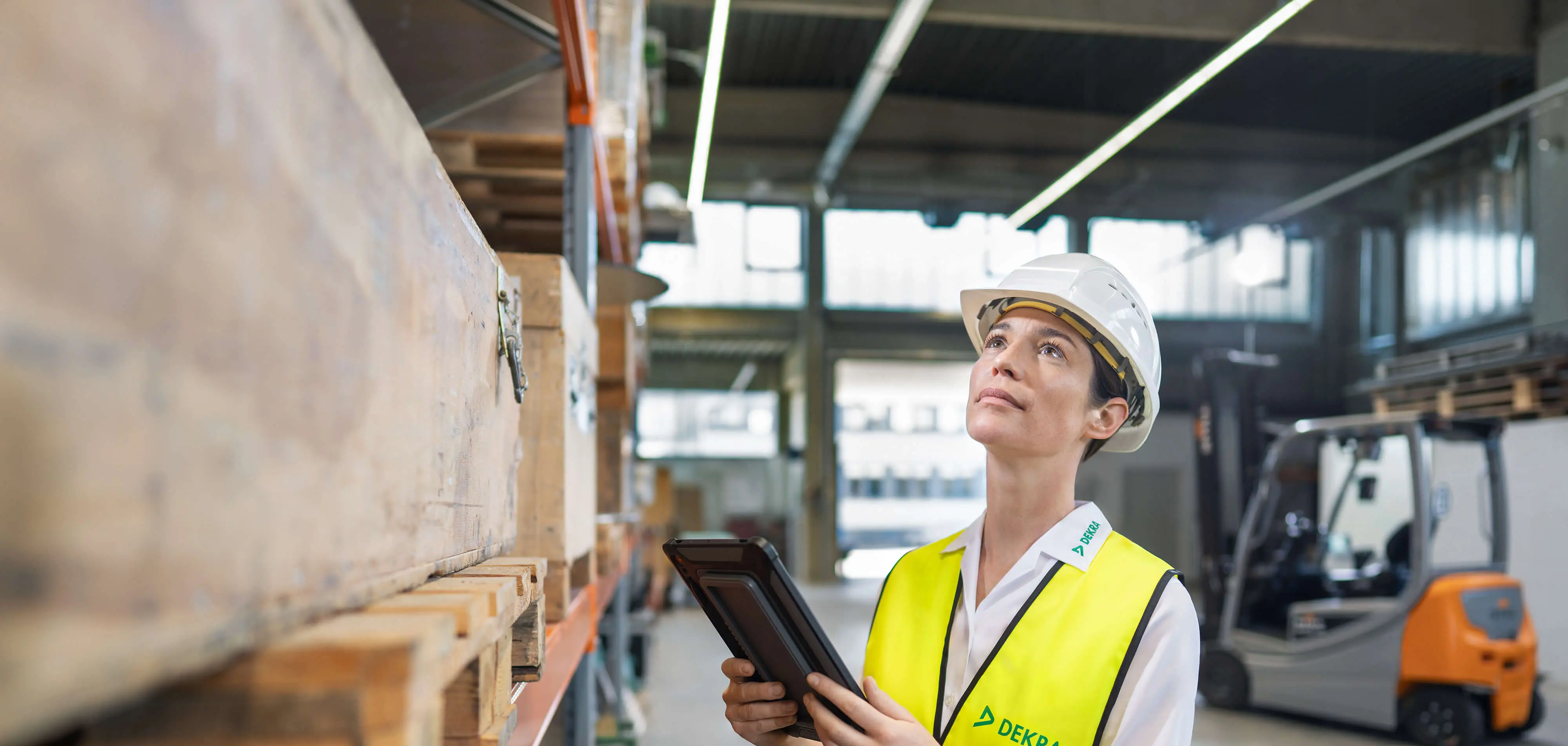 Fachkraft für Arbeitssicherheit mit Arbeitskleidung Klemmbrett in einer Lagerhalle Fachkraft für Arbeitssicherheit mit Arbeitskleidung Klemmbrett in einer Lagerhalle