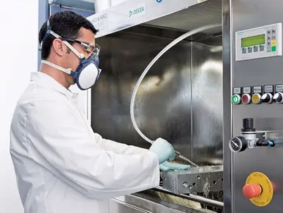 Sachverständiger mit Mundschutz vor Laboranalysegerät Sachverständiger mit Mundschutz vor Laboranalysegerät