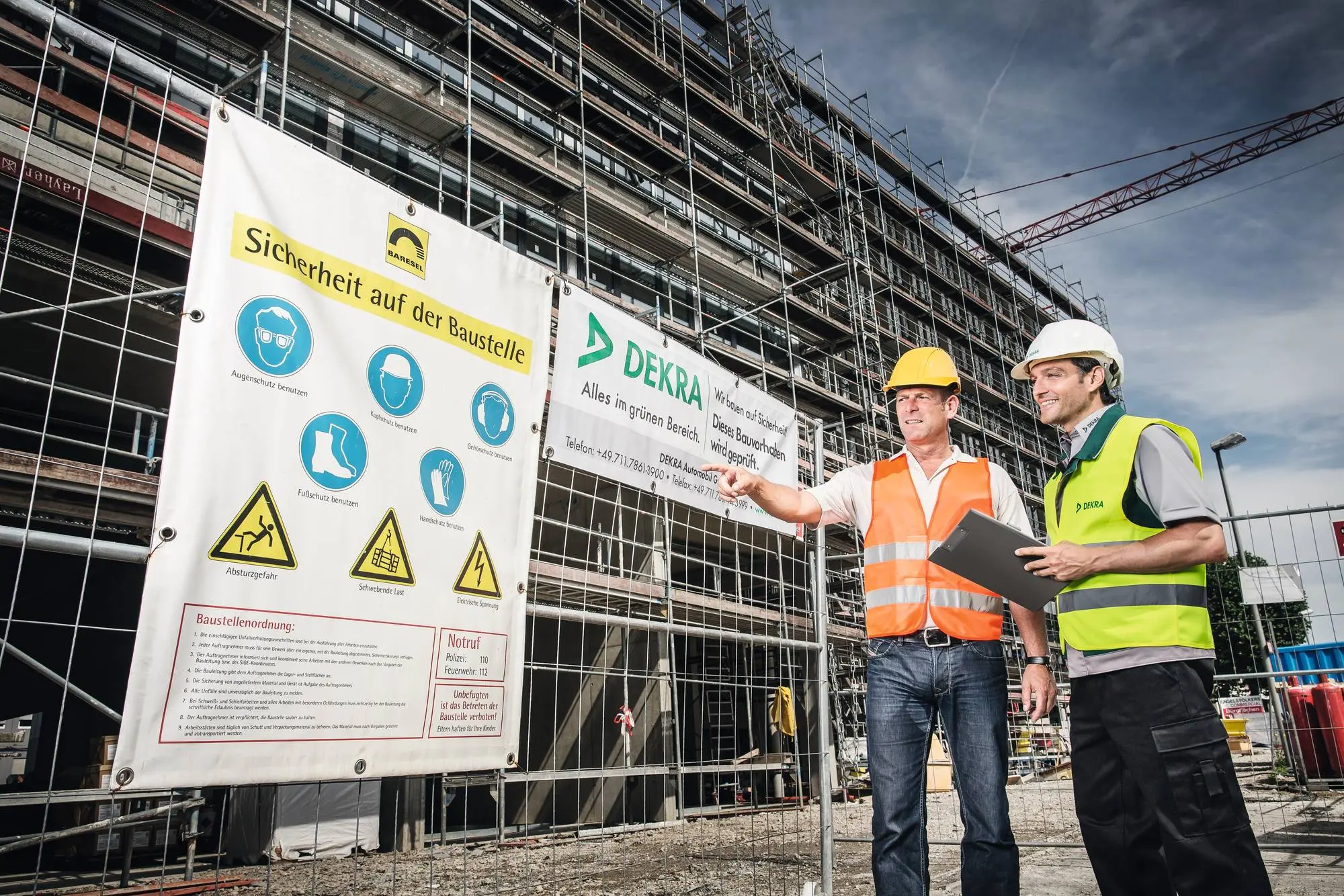 Zwei Männer vor Sicherheitsvorschriften an einer Baustelle Zwei Männer vor Sicherheitsvorschriften an einer Baustelle