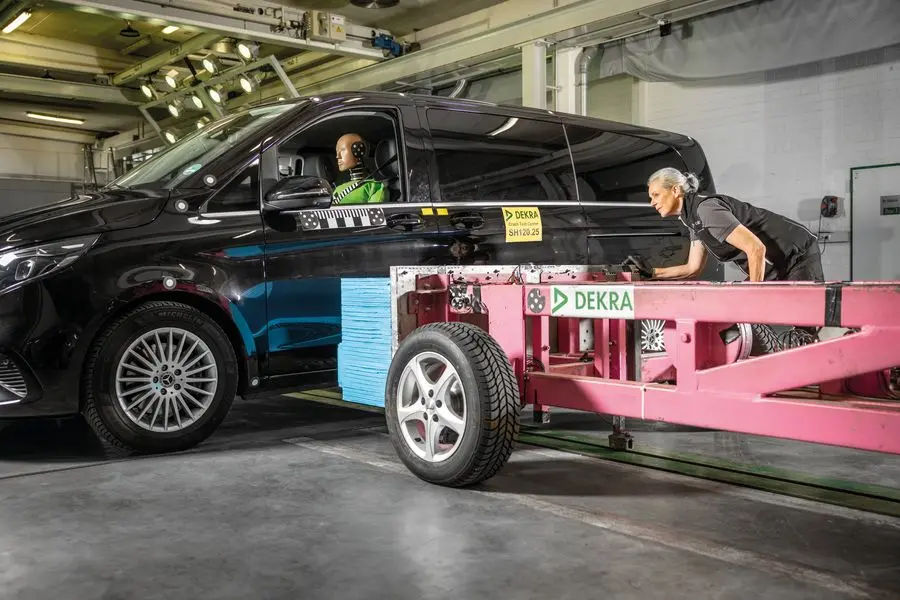 Prüferin präpariert Barriere seitlich an das Auto