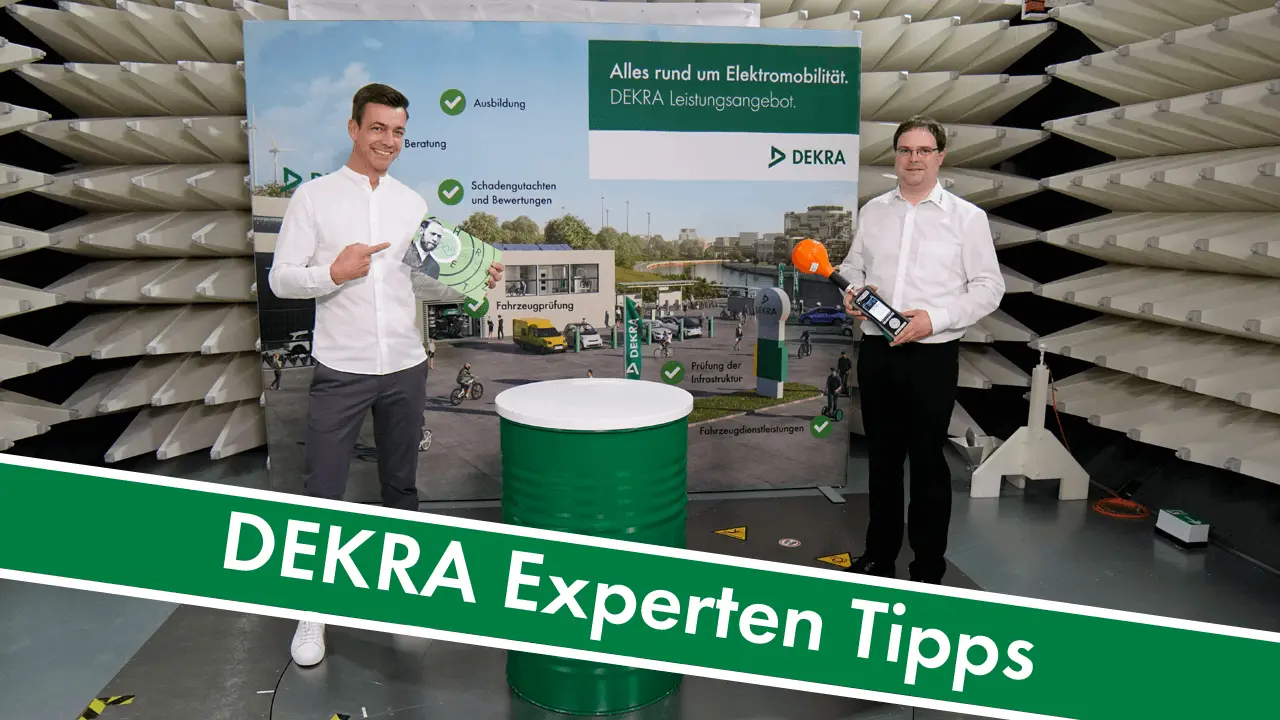 Tobias Wobbe steht neben DEKRA Experten und zeigt auf Bild