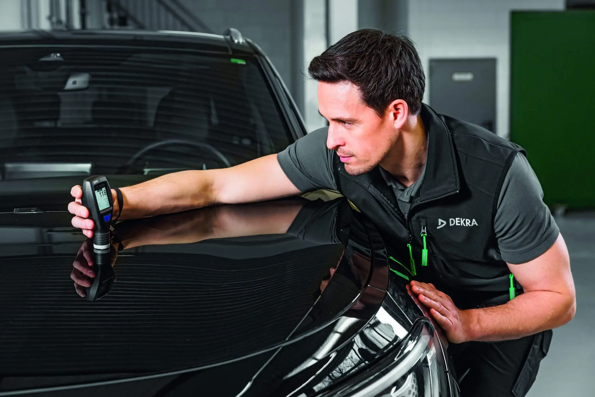 DEKRA Prüfer begutachtet Autoscheibe